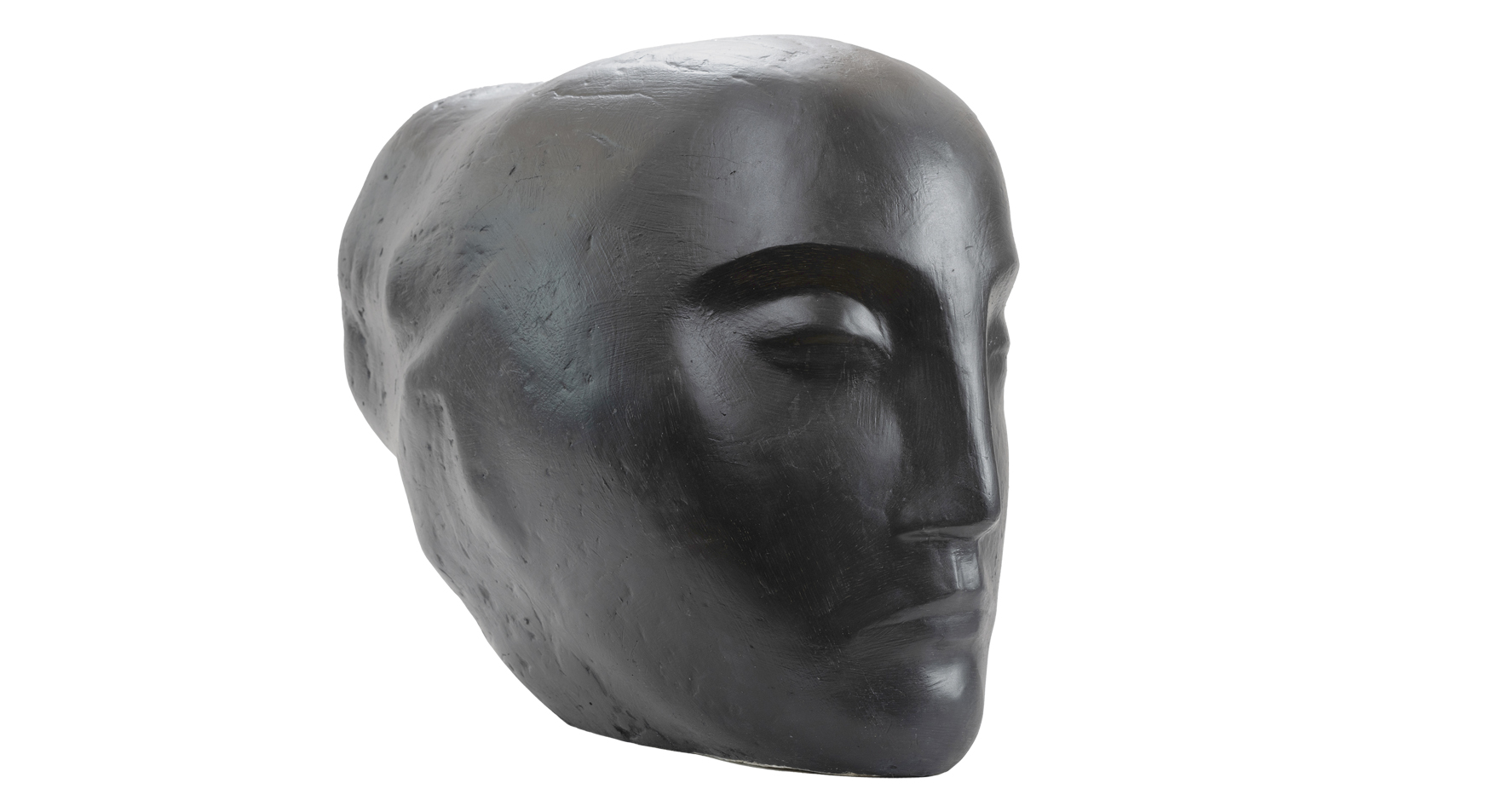 Barbara Loeffler-Zbrożyna

urodzona w 1923 roku w Lublinie – zmarła w 1995 roku Warszawie

Głowa 

lata pięćdziesiąte dwudziestego wieku

Gips polichromowany

wymiary: 36 na 24 na 48 cm

Muzeum Zamoyskich w Kozłówce

numer inwentarza: MPK/SW/160

 

Na zdjęciu widnieje rzeźba głowy ukazanej z profilu, pod lekkim kątem, co nadaje jej subtelnej dynamiki. Wykonana z ciemnego, niemal czarnego gipsu polichromowanego o matowej, chropowatej powierzchni, nosi wyraźne ślady dłuta lub palców artysty.
Forma głowy jest masywna, opływowa – niemal monumentalna w swojej prostocie. Rysy twarzy zredukowane zostały do podstawowych linii: syntetyczne, oszczędne, lecz pełne wyrazu. Zamknięte oko z wyraźnie zarysowaną powieką układa się w spokojny łuk, a grube, mocno zarysowane brwi potęgują wrażenie wewnętrznego skupienia.
Nos – wąski i prosty – wraz z zaciśniętymi, beznamiętnymi ustami podkreśla powagę twarzy. Miękka, lecz wyczuwalna linia szczęki i kości policzkowych buduje harmonijną strukturę. Tył głowy jest gładki, pozbawiony detali – bez śladu włosów czy uszu – jakby wyrzeźbiony z myślą o esencji, a nie o portrecie.
Całość emanuje spokojem, ciszą i skupieniem. Rzeźba zdaje się kontemplować własne istnienie – minimalistyczna, ascetyczna, niemal medytacyjna. To forma, która mówi więcej przez to, co przemilcza, niż przez to, co przedstawia.