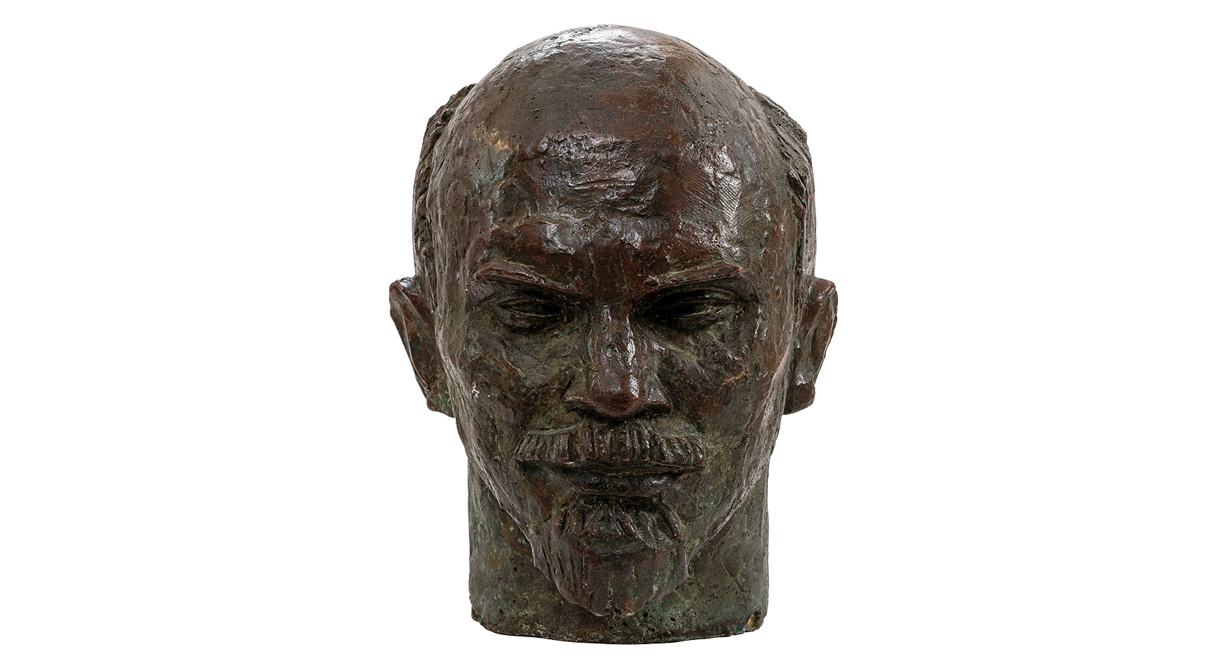 Franciszek Xawery Dunikowski
urodzony w 1875 roku w Krakowie – zmarł w 1964 roku w Warszawie

Głowa Lenina

powstała w 1957 roku

Brąz

wymiary: 48 x 32 x 38 cm

Muzeum Zamoyskich w Kozłówce

numer inwentarza: MPK/SW/2015

Popiersie przedstawia mężczyznę w średnim wieku lub nawet nieco starszego – Włodzimierza Lenina. Rzeźba wykonana z ciemnego brązu, pokryta zielonkawą patyną, zyskuje klasyczny, niemal pomnikowy wymiar. Patyna dodaje całości szlachetności i historycznego ciężaru, budując wrażenie trwałości i nieprzemijalności.

Twarz jest wyrazista, silnie zarysowana – dominuje wysokie, wypukłe czoło oraz mocno zaznaczone łuki brwiowe, pod którymi kryją się głęboko osadzone oczy. Ich spojrzenie – lekko przymrużone, przenikliwe – sprawia wrażenie skupionego, analizującego, niemal oceniającego. Prostoliniowy nos oraz ściśle zaciśnięte usta wzmacniają surowy wyraz twarzy, nad którym góruje precyzyjnie opracowany wąs. Krótka broda dopełnia starannie wymodelowana kompozycję, jakby wycięta z brązu ostrzem determinacji.

Czaszka niemal całkowicie łysa, z jedynie śladowym zaznaczeniem krótkich włosów po bokach, kontrastuje z silnie wymodelowaną dolną partią twarzy. Uszy – odstające, lekko asymetryczne – wprowadzają nutę realizmu do niemal ideowego portretu.

Powierzchnia rzeźby nie została całkowicie wygładzona – widoczne są ślady modelowania, drobne nierówności i ścieżki dłoni rzeźbiarza. To świadoma decyzja artystyczna – struktura materiału podkreśla surowość i bezpośredniość postaci, nadając jej autentyczność i wewnętrzną siłę.

Całość emanuje powagą, skupieniem i nieugiętością. To nie tylko realistyczne przedstawienie konkretnej postaci, lecz także uosobienie władzy, kontroli i ideologicznej pewności. Rzeźba działa nie tylko formą, ale też nastrojem – dominującym, świadomym i niepodważalnym.